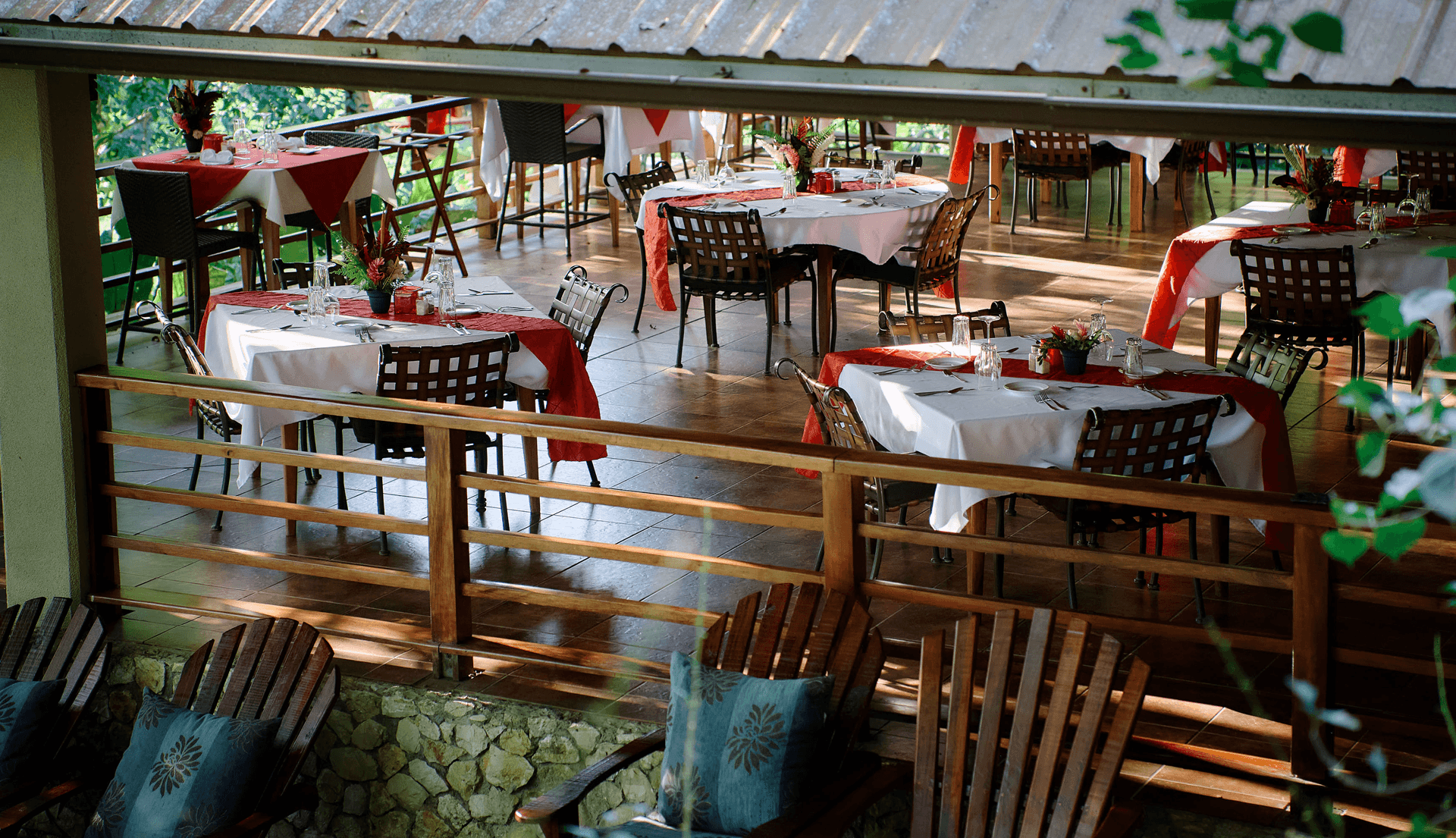 A view of a restaurant with elegantly set tables and wooden chairs.